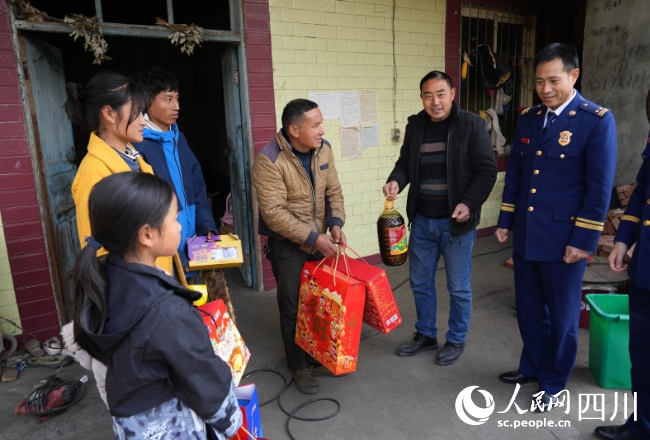 1月17日，在雅安市石棉縣王崗坪彝族藏族鄉(xiāng)愛國村，消防救援人員為正在看望慰問肖華平一家。李從林?jǐn)z