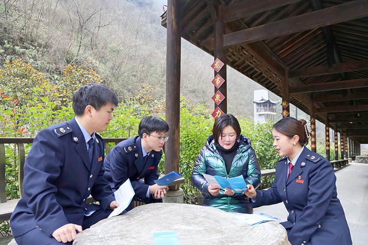 稅務(wù)干部向胡曉玲宣傳稅收政策。達(dá)州市稅務(wù)局供圖