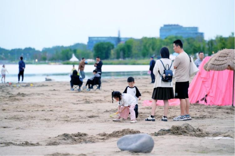 小朋友在興隆湖畔玩海沙。天府新區(qū)融媒體中心供圖