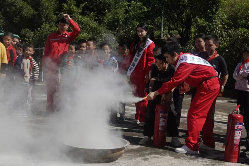 教授小學(xué)生滅火器使用操作。蘇云婷攝